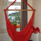 Hængekøjestol i rødt bomuldsstof giver komfort.