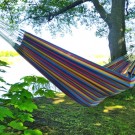 Den hængekøje med farverige striber på azurblå bund bringer glæde og godt humør