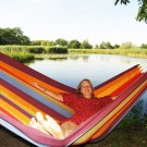 Den hængekøje med striber i regnbuens farver giver komfort og nydelse for to.